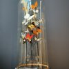 Antique bell jar filled with a mix of colorful butterflies in autumn colors