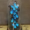 Kleine antike Glocke gefüllt mit blauen Schmetterlingen