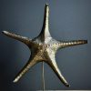 Gemetalliseerde zeester op marmeren sokkel