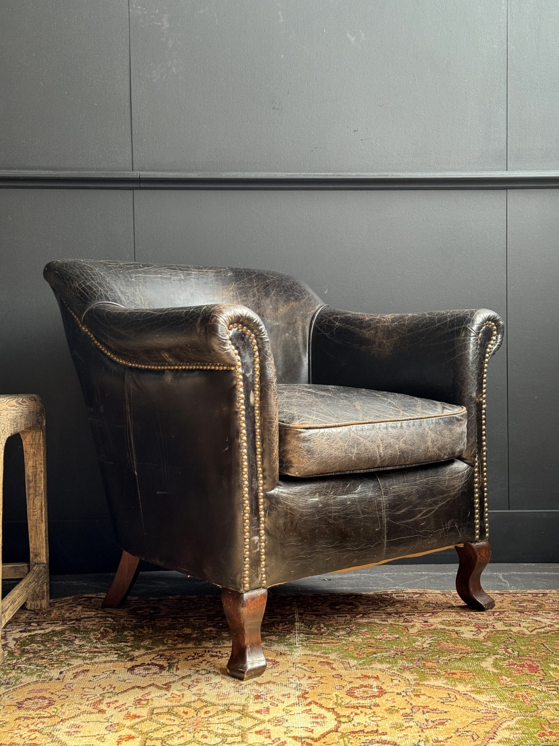Oude zwarte clubfauteuil