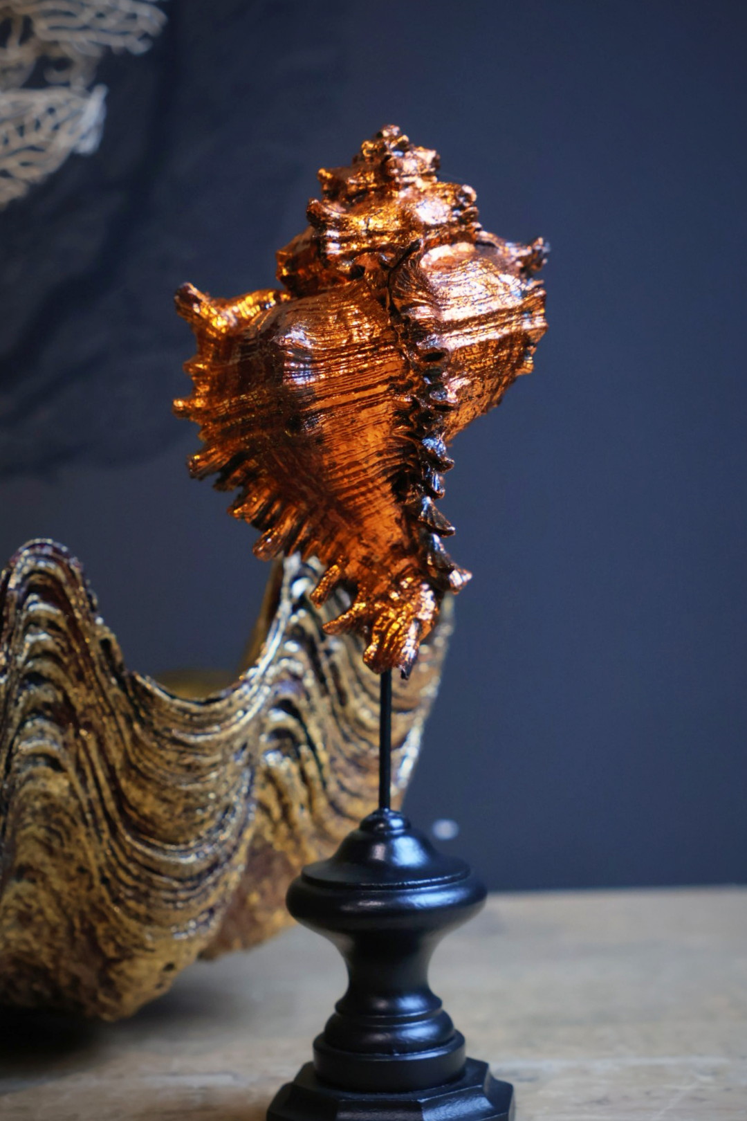 Oranje gouden schelp op sokkel